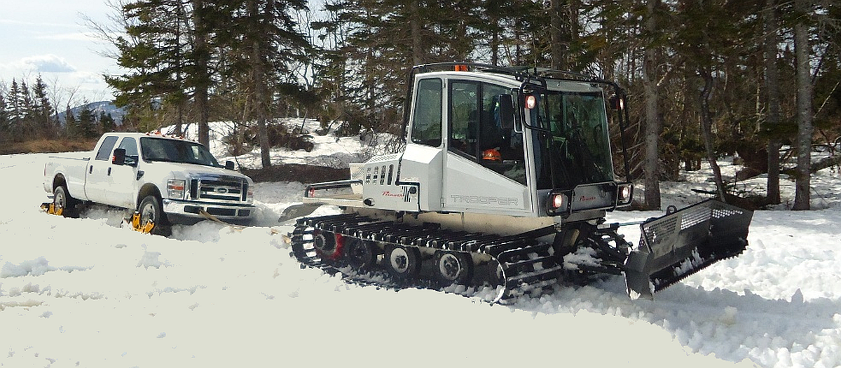 Snowcat and a 4WD pick-up truck on tracks