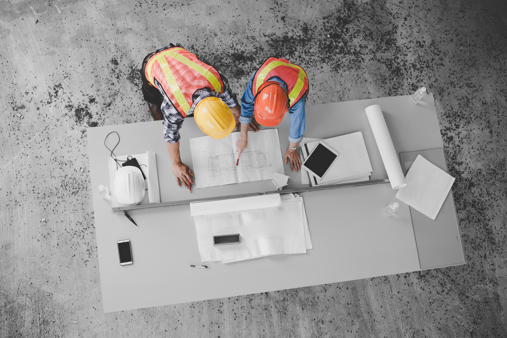 workers looking over charts on table