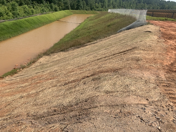 sloping hill to muddy water