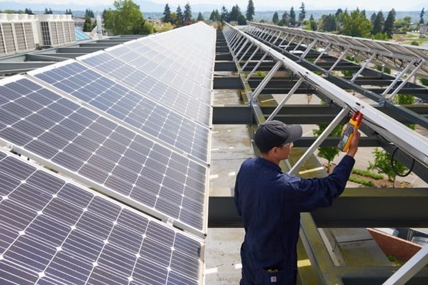 man measuring side of solar panel