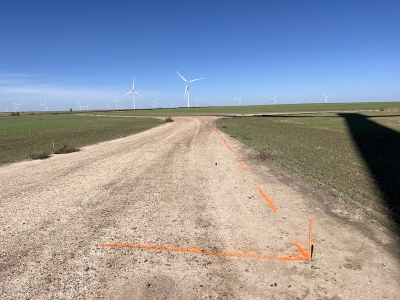 wind turbines blue sky dirt road