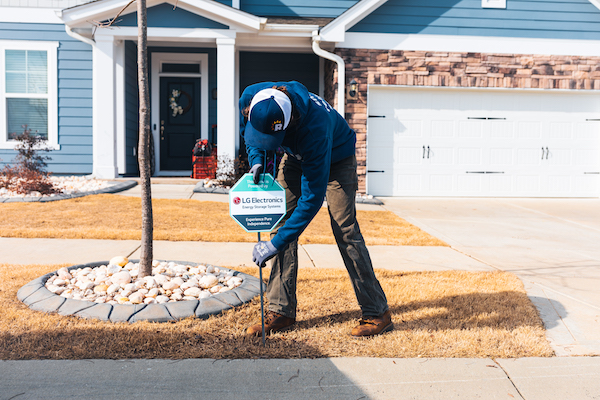 guy putting a sign in a yard