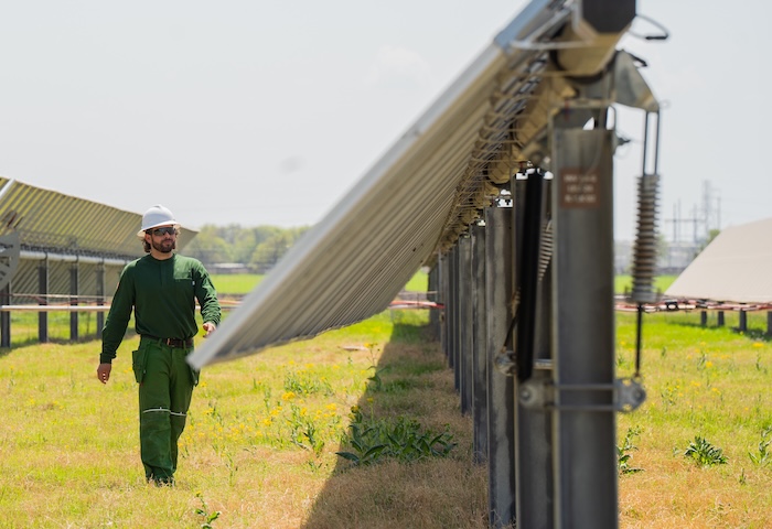 guy walking next to solar panel