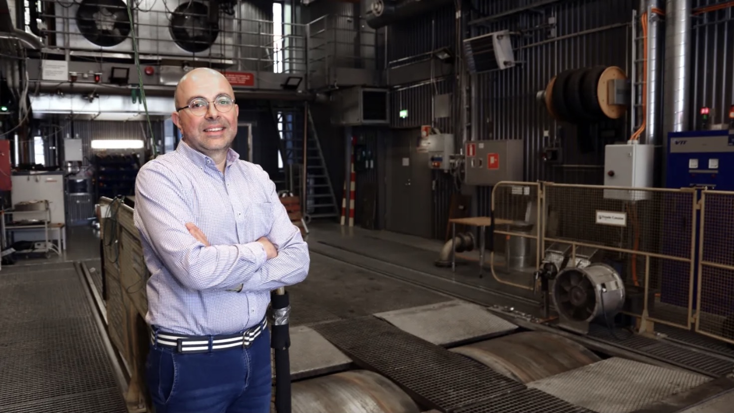 man with arms crossed in front of machinery