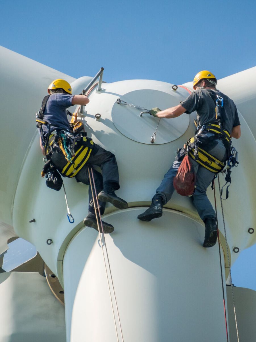 2 men hanging off turbine